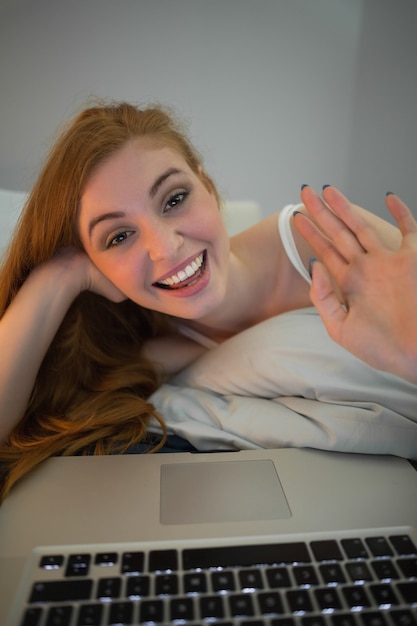 Redhead feliz ondulando no laptop no chat de vídeo