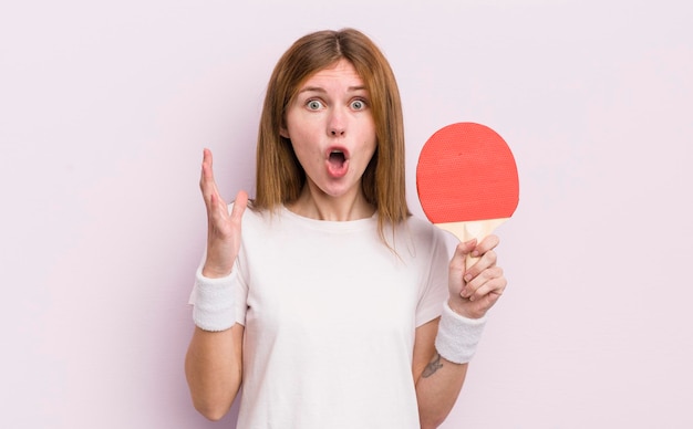 Redhead hübsches Mädchen extrem schockiert und überrascht Ping-Pong-Konzept