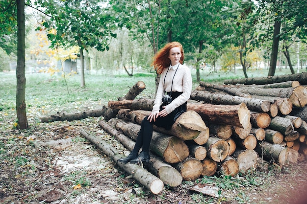 Redhead Mädchen hält Kamera im Herbst Park