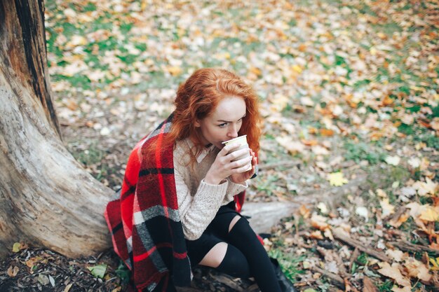 Redhead Mädchen mit Kaffee im Herbst Park