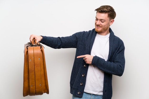 Redheadmann, der einen Weinleseaktenkoffer anhält