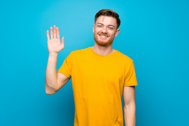 Redheadmann, der mit der Hand mit glücklichem Ausdruck begrüßt