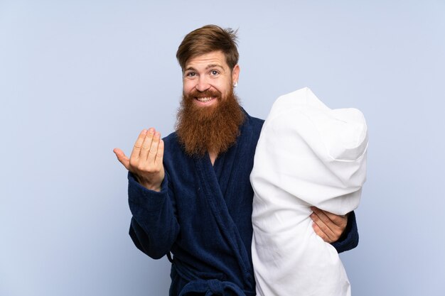 Redheadmann in den Pyjamas über der getrennten Wand, die einlädt, mit der Hand zu kommen. Schön, dass Sie gekommen sind