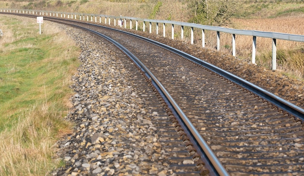 Redondeo de ferrocarril abandonado oxidado vacío girando una sola vía de ferrocarriles