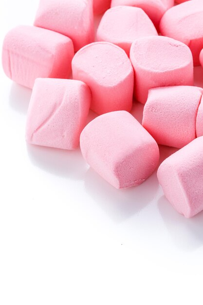 Redondos grandes marshmallows rosa em um fundo branco.