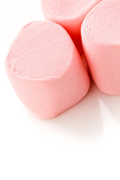 Redondos grandes marshmallows rosa em um fundo branco.