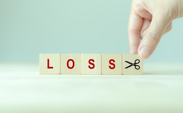 Reducción de riesgos concepto de gestión de riesgos financieros o empresariales Estrategias empresariales y reducción de riesgos corporativos Iconos de riesgo y tijeras en bloques de cubos de madera mínimo fondo y espacio de copia