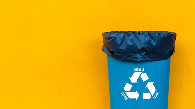 Foto reduce reuse recycle symbol mit müllkorb auf gelbem hintergrund ökologisches konzept ökologische metapher für ökologische abfallwirtschaft und nachhaltigen und ökonomischen lebensstil