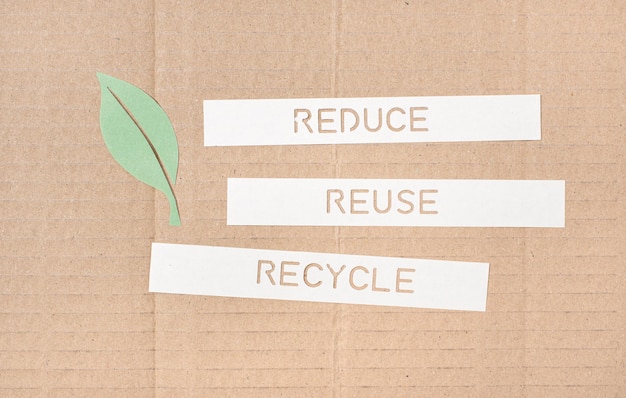 Reduza o conceito de Reutilização Reciclagem Folha e tiras de papel com texto recortado em um fundo de papelão