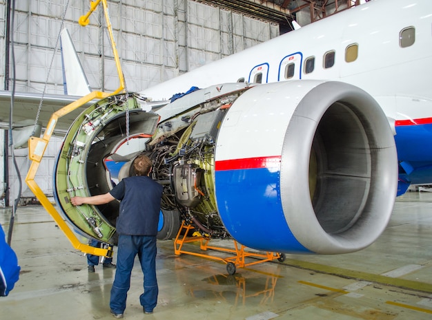 Foto reemplazando el motor en el avión, la gente que trabaja toca. concepto de mantenimiento de aeronaves.