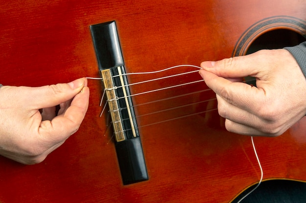 Reemplazo e inserción de cuerdas de nailon en una guitarra clásica. lección para un músico