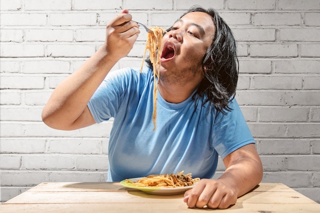 Refeição de homem gordo asiático o espaguete de fast-food