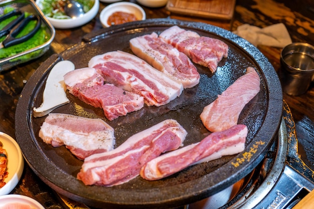 Refeição de porco preto panfrito no restaurante da Coreia, cozinha deliciosa e deliciosa de comida coreana em chapa de ferro com alface, estilo de vida de espaço de cópia