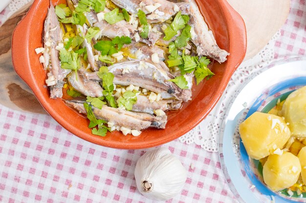 Foto refeição tradicional de carapau do atlântico português com alho, azeite e batata.