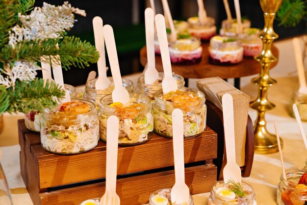 Refeições. porções convenientes de saladas com camarões em potes pequenos. bela configuração de mesa original para banquete.