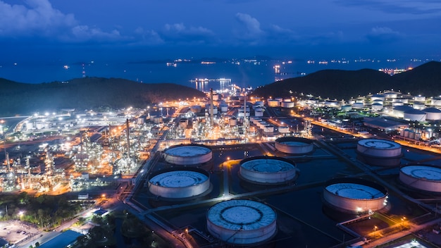 Refinaria de petróleo e indústria petroquímica de gás com área de tubulação de aço de tanques de armazenamento na vista aérea do crepúsculo