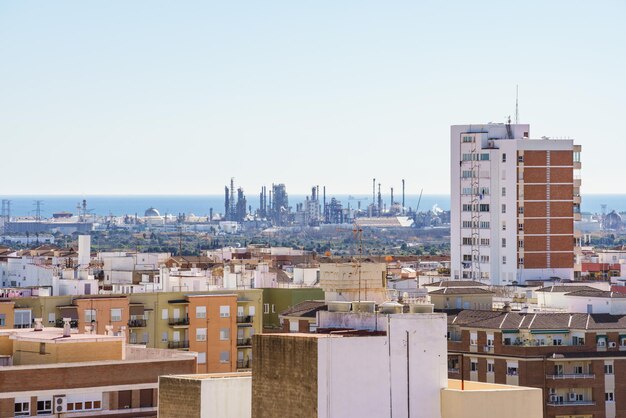 Refinería de petróleo cerca de una ciudad y el mar