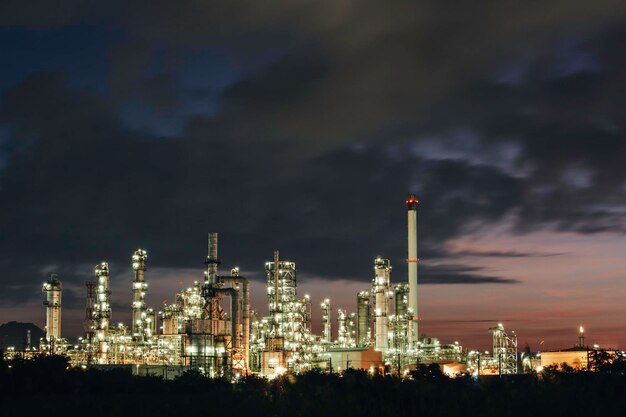 Refinería de petróleo y columna de planta y torre de la industria petroquímica en la industria de gas y petróleo de oleoductos con cielo rojo sol el fondo de la mañana