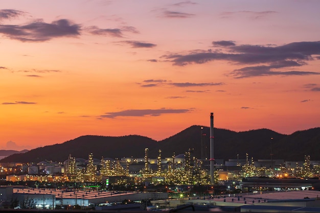 Refinería de petróleo y planta de la industria petroquímica en la industria del petróleo y el gas con el cielo nublado y el fondo de la puesta de sol.