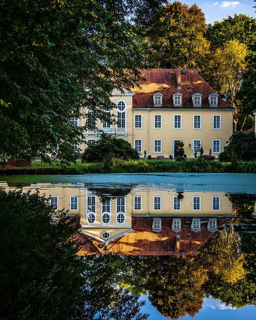 Foto reflejo de árboles y edificios en el lago