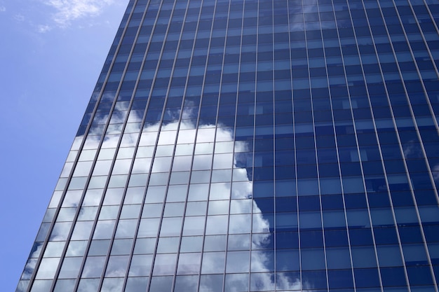 Reflejo de cielo azul y nubes en un edificio de cristal