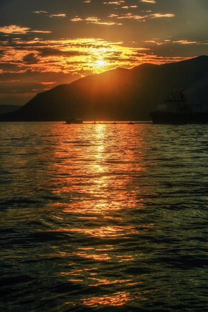 Reflejo del cielo colorido naranja en la superficie del agua del mar Adriático en Montenegro
