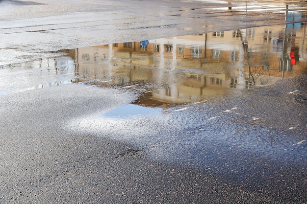 Reflejo de la ciudad en un charco en el pavimento