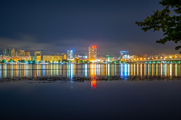 Reflejo de la ciudad nocturna en un amplio río tranquilo