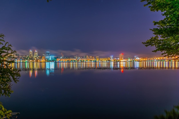 Reflejo de la ciudad nocturna en un amplio río tranquilo