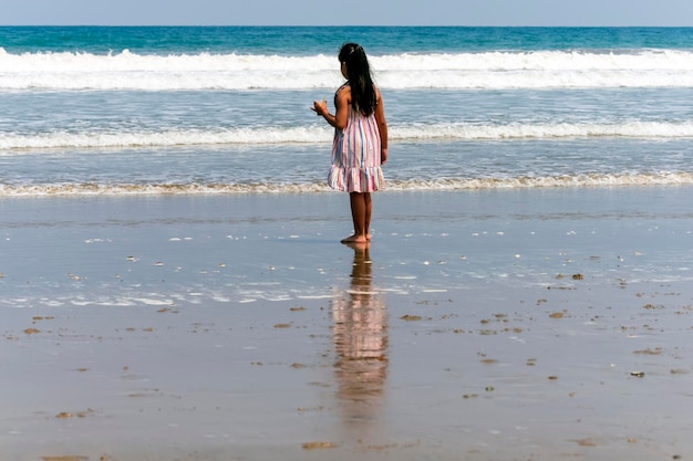 reflejo em la playa de hermosa niña