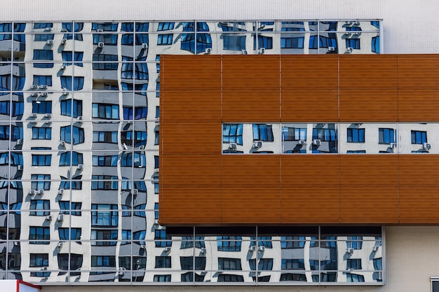 Reflejo en una gran ventana de una parte de un edificio de varios pisos