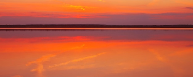 Reflejo de una hermosa puesta de sol dorada sobre el agua