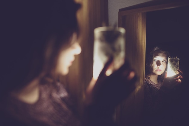 Foto reflejo de una mujer sosteniendo una bebida de piña en un vaso