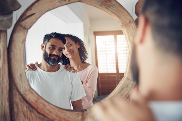 Foto reflejo de sonrisas y mañana con una pareja en el espejo para despertar apoyo y amor compromiso feliz y felicidad con el hombre y la mujer vinculándose en casa para motivarse ayudando y cuidando juntos