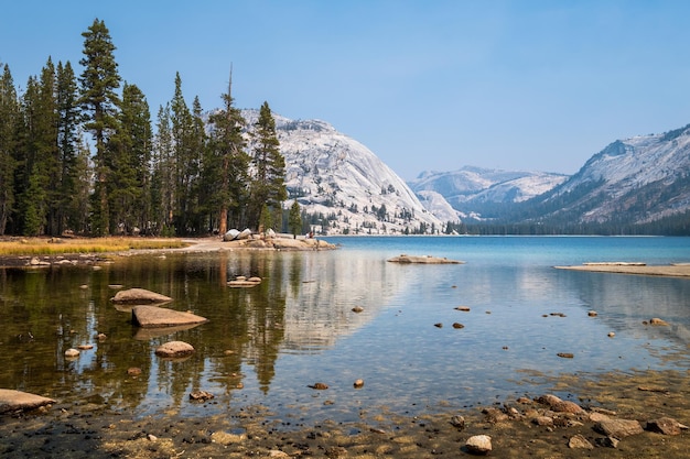 Reflejos perfectos de las montañas y los árboles sobre el lago Tenaya en Yosemite NP