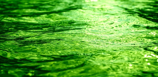 Reflejos verdes en la superficie del agua Movimientos de luz en las olas Imagen de fondo perfecta