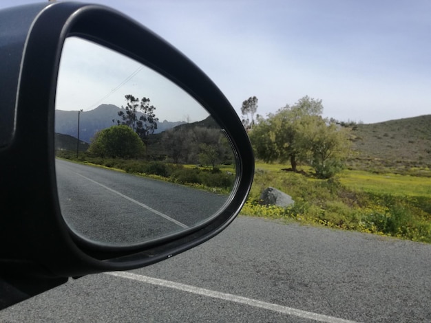 Reflexão da estrada no espelho lateral do automóvel