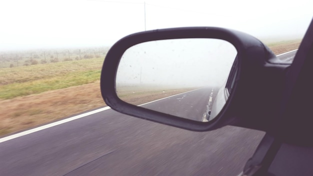 Foto reflexão da estrada no espelho retrovisor lateral