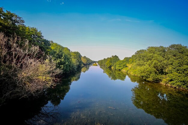 Foto reflexão de árvores no lago contra o céu azul