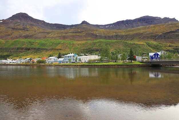 Reflexão de casas no lago contra montanhas