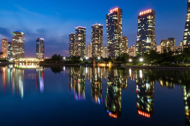 Reflexão de edifícios iluminados na água à noite