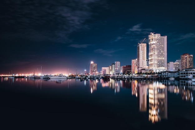Reflexão de edifícios iluminados no rio à noite