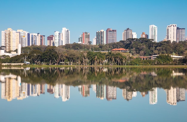 Reflexão de edifícios no lago contra o céu limpo