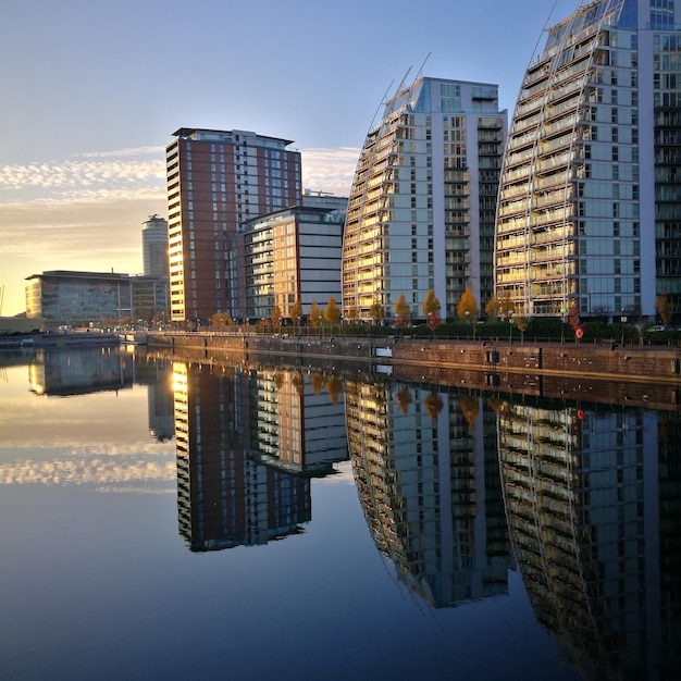 Reflexão de edifícios no lago durante o pôr do sol