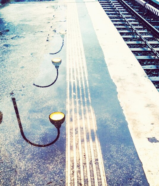Reflexão de luzes em plataformas ferroviárias molhadas