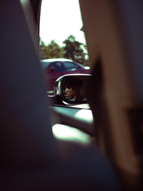 Reflexão de um homem no espelho do carro