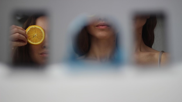 Reflexão de uma mulher cobrindo uma fatia de laranja