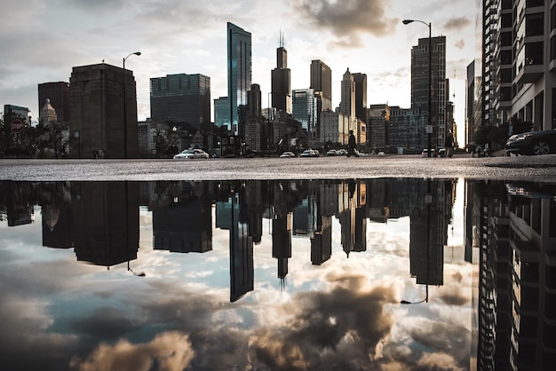 Foto reflexão do edifício da cidade na poça na rua