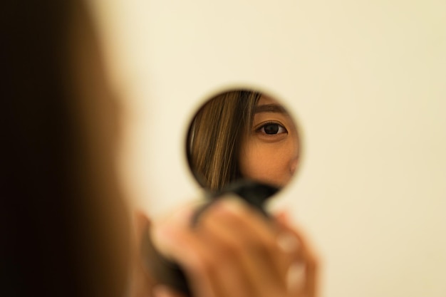 Reflexão do rosto da mulher no espelho de maquiagem