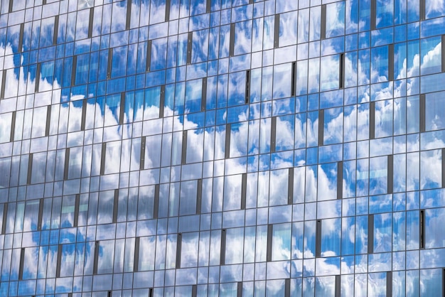 Reflexão no céu azul do edifício com nuvens claras